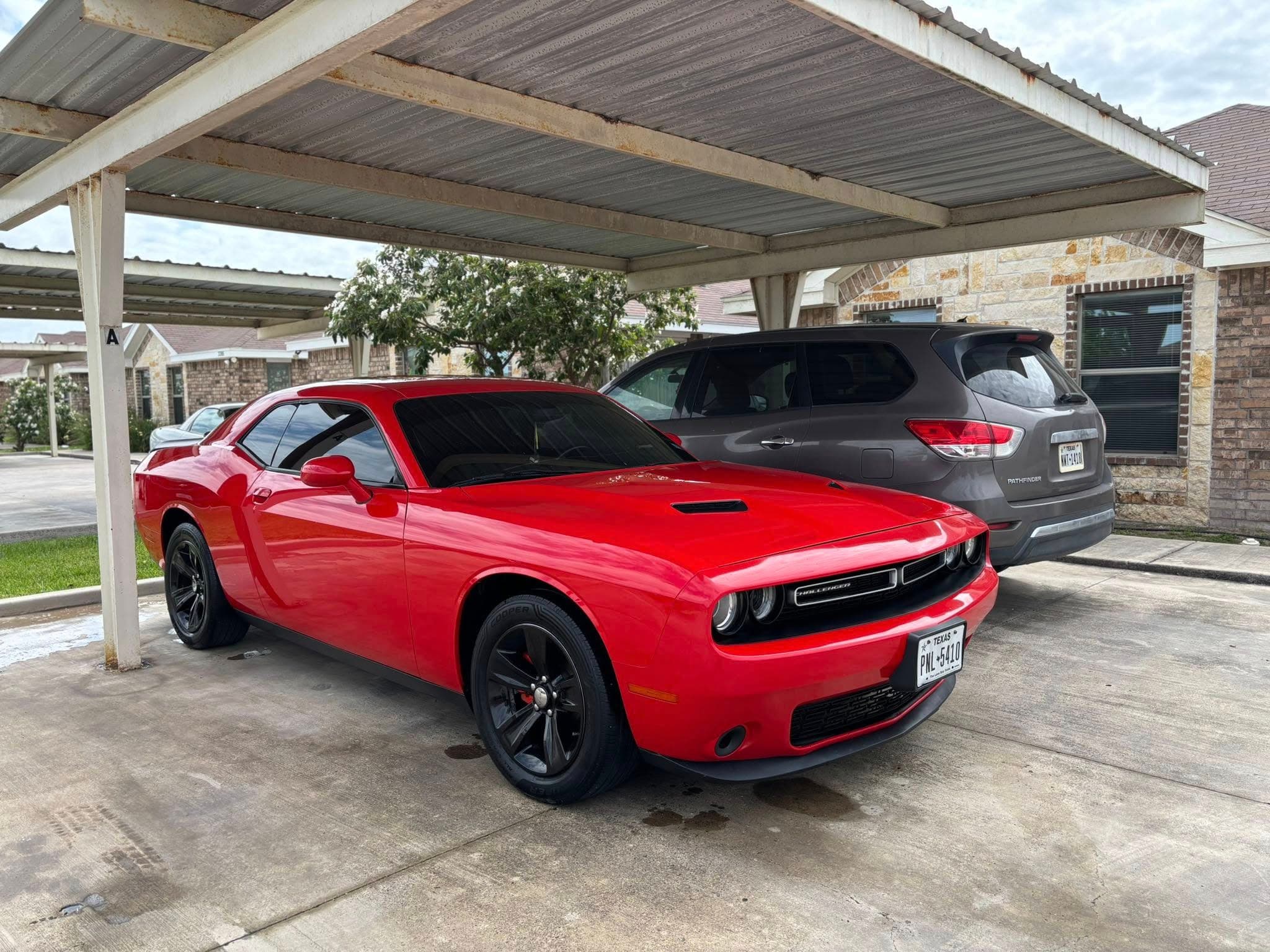 Bright red Dodge Challenger with deep gloss parked on a driveway